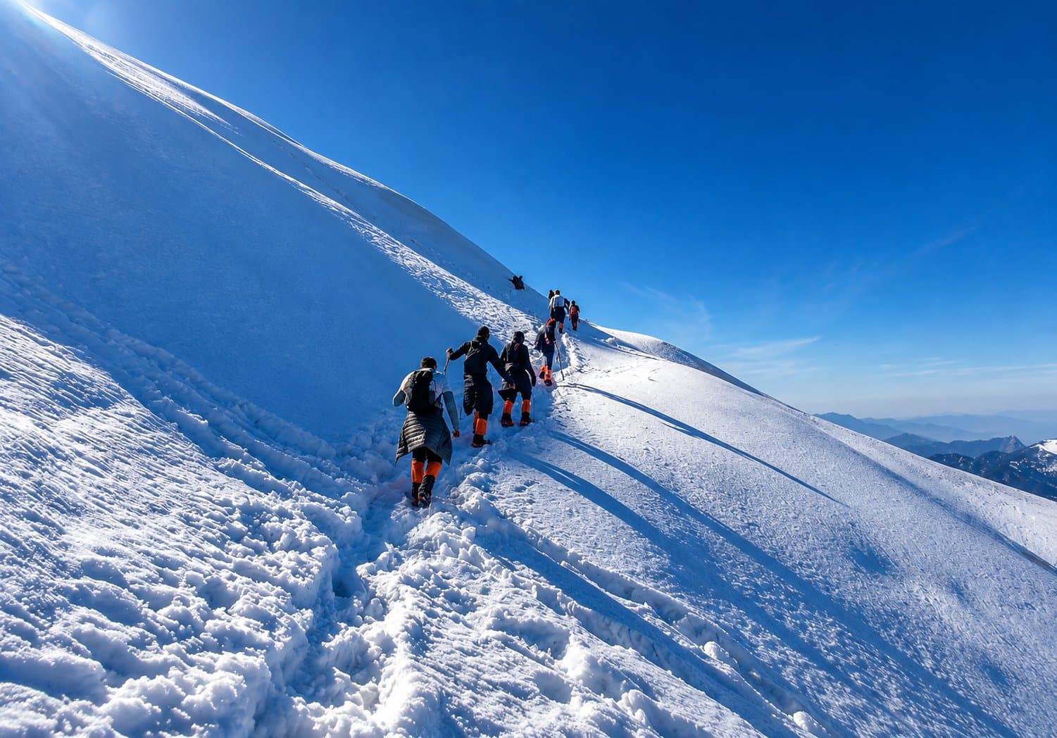 Trekkers ascending the snow-covered ridge to Chandrashila Peak