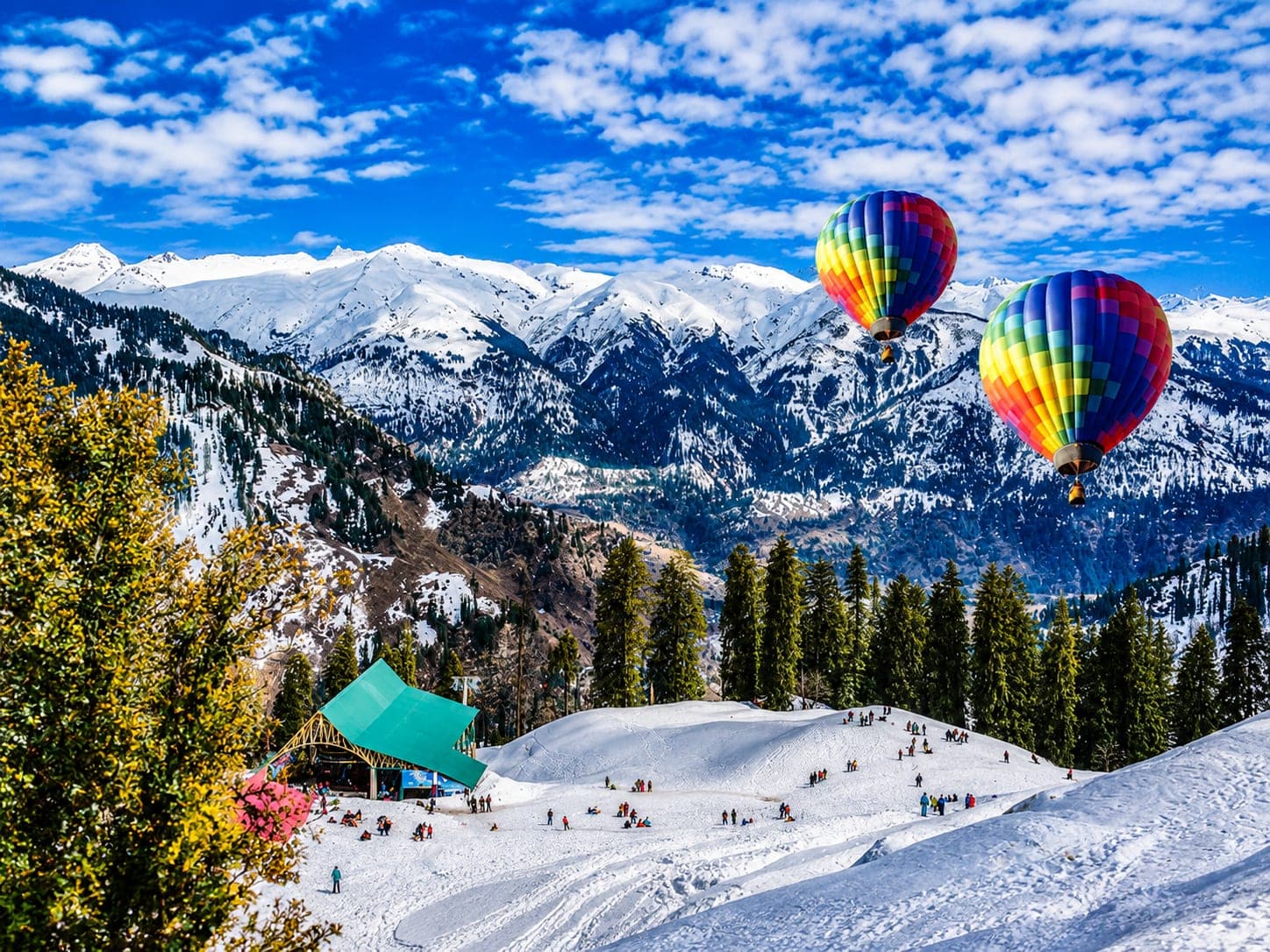Hot air balloons over the snow-covered slopes of Solang Valley near Manali