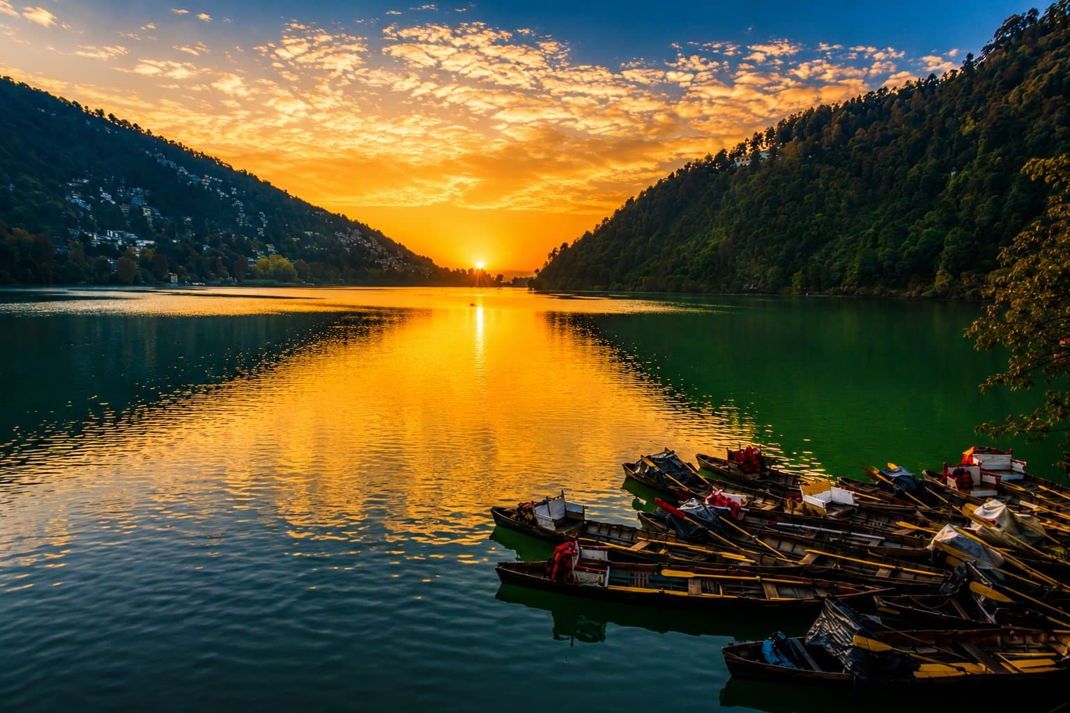 Naini Lake at sunset with rowboats moored at the shore
