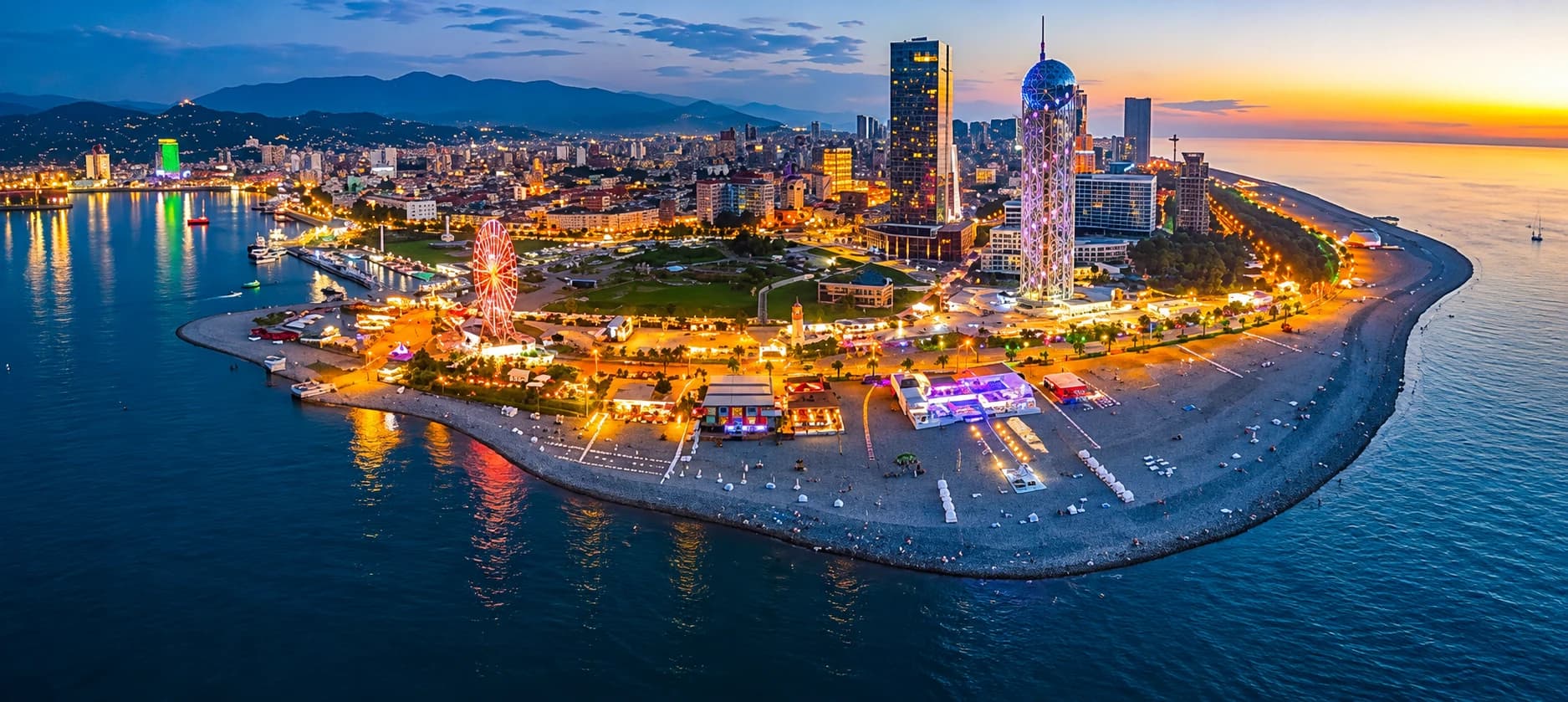 Aerial sunset view of Batumi's seafront boulevard, Ferris wheel and Alphabet Tower on the Black Sea coast