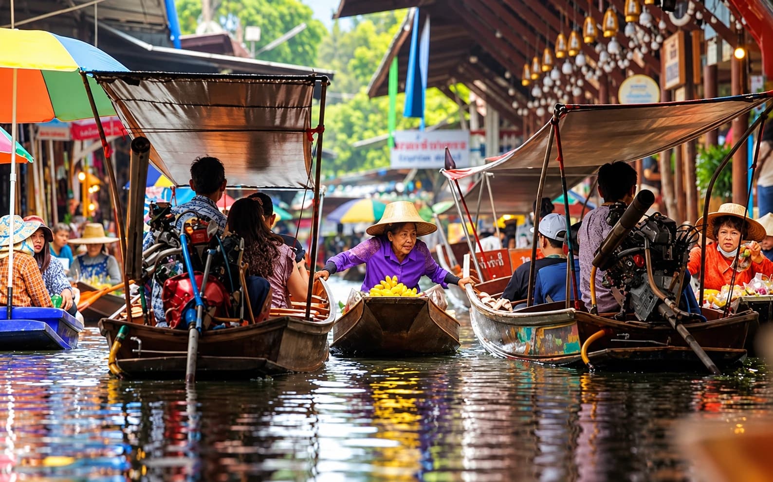 Vendor boats laden with fruit navigating the narrow canal at Damnoen Saduak floating market