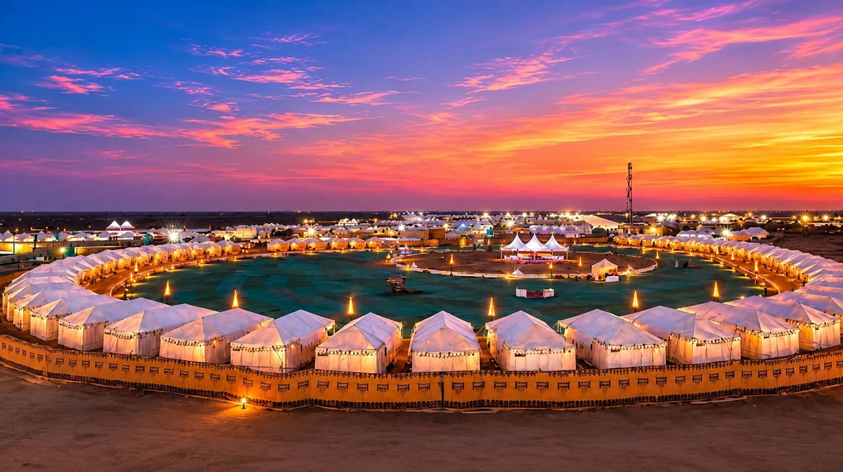 Rann Utsav's circular white tent city at Dhordo lit up under a vivid sunset sky